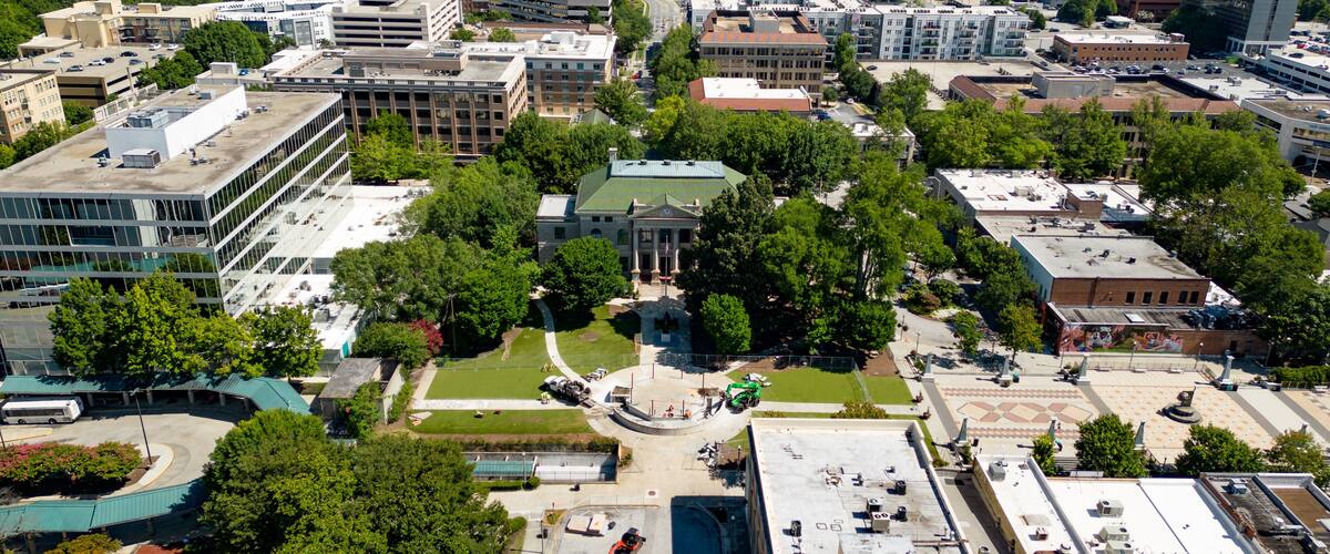 An aerial view of a university campus with multiple buildings, green spaces, and a central lawn.