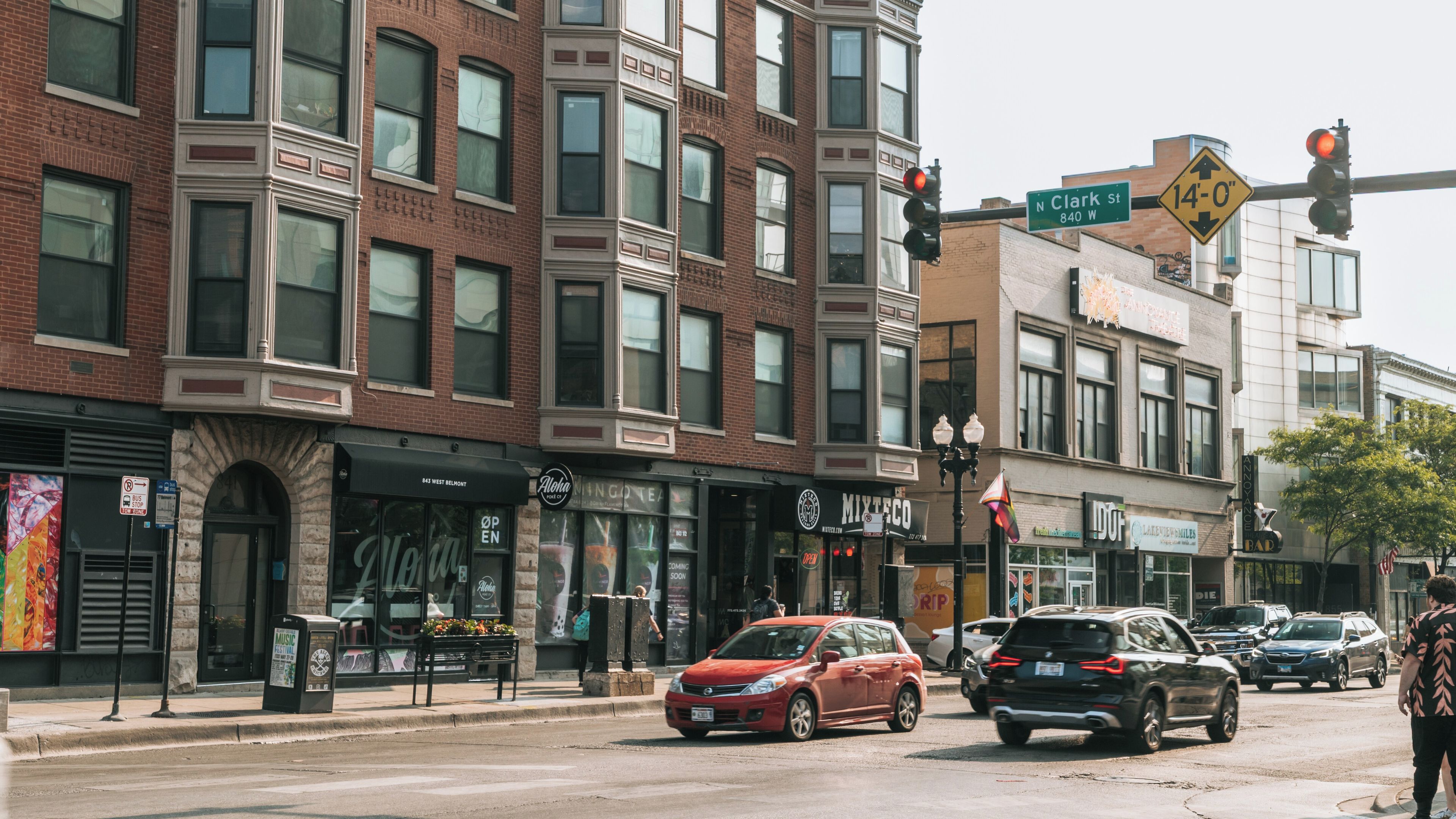 A street corner with brick buildings, a traffic light, and a street sign for Clark St.