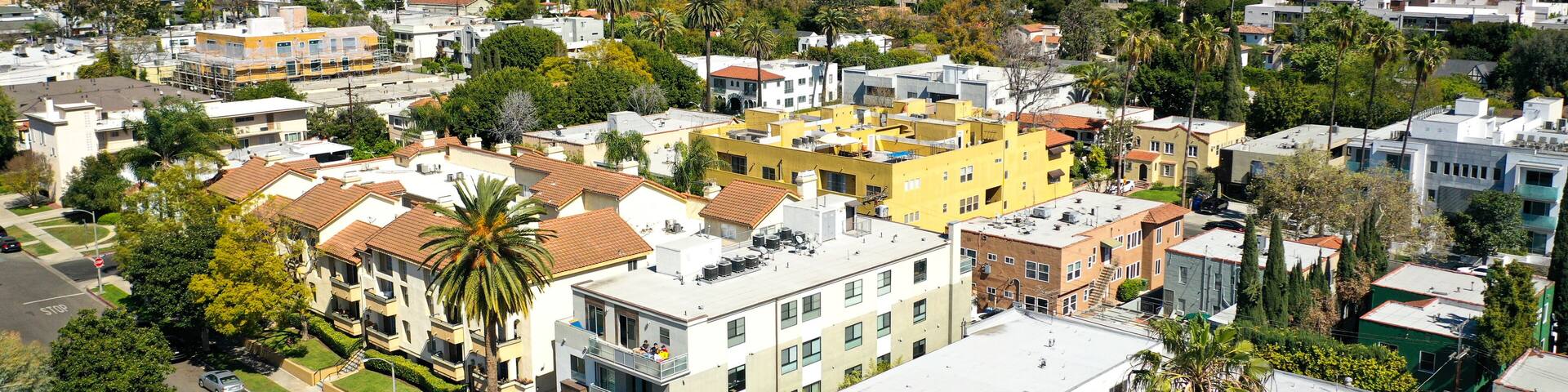 A cityscape with a mix of modern and traditional architecture, surrounded by hills and mountains.