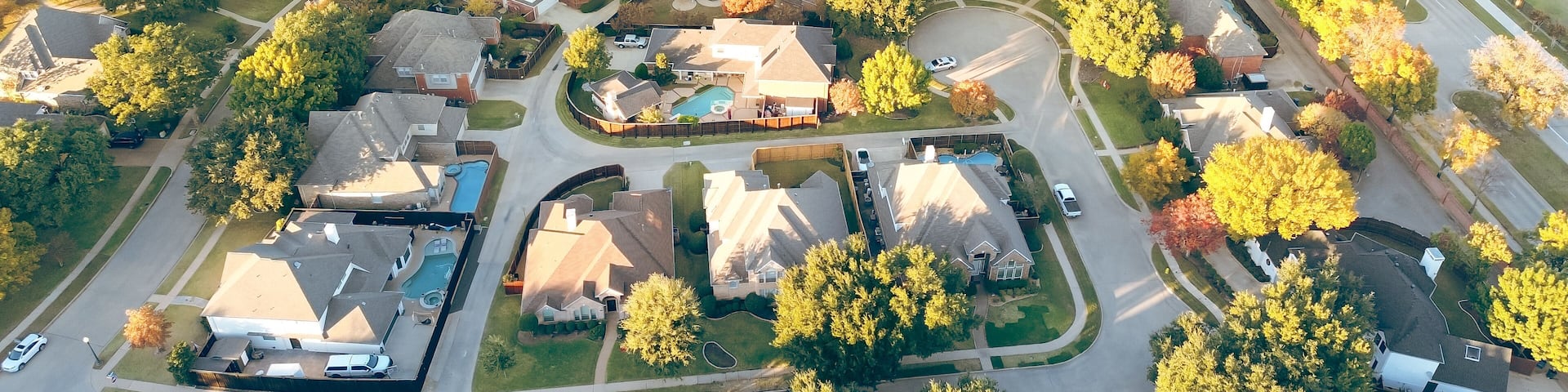 Suburban school district in upscale lakeside residential community along MacArthur boulevard in Coppell, suburbs Dallas, Texas, colorful autumn leaves over row of two story large suburban houses