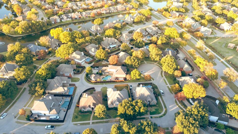 Suburban school district in upscale lakeside residential community along MacArthur boulevard in Coppell, suburbs Dallas, Texas, colorful autumn leaves over row of two story large suburban houses