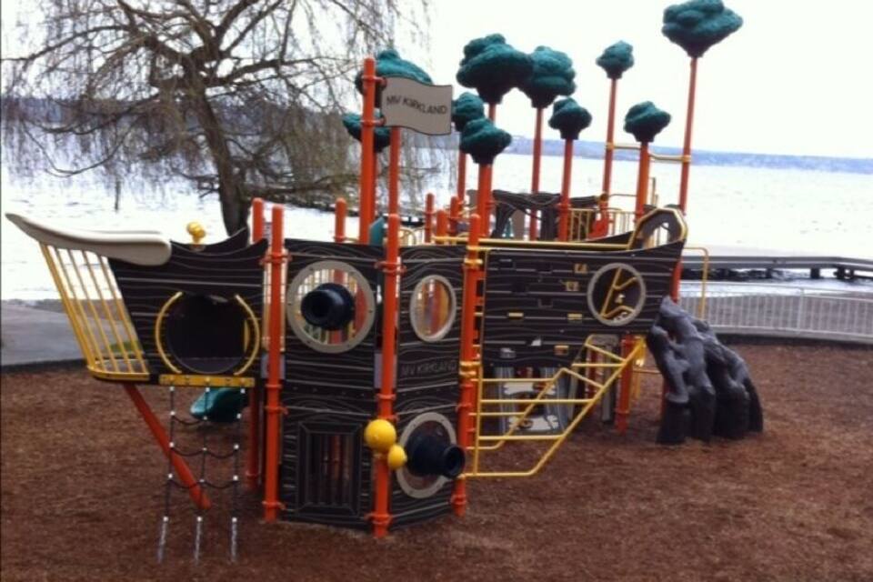 A pirate ship play structure near a body of water.