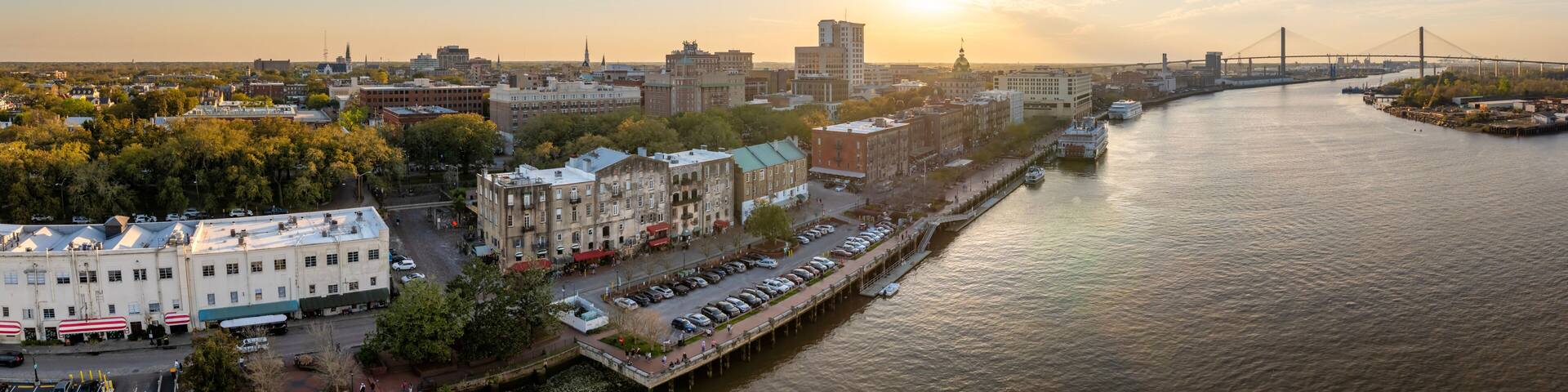 A river with a bridge, buildings, and a boat.