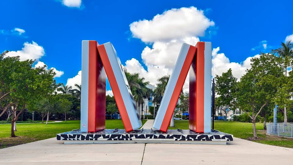 Miami, Florida: Feb 25, 2025 The bold red and white M sculpture stands in the center of Jose Milton Park, formerly known as Albert Pallot Park, a waterfront public space in Miami