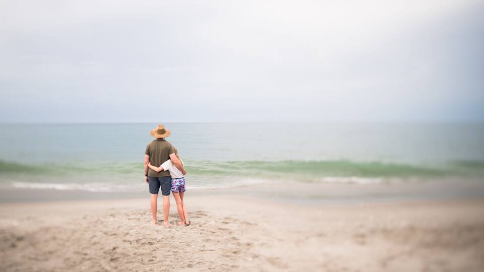Man and Young Girl Standing Looking Out at the Ocean in Indialantic FL