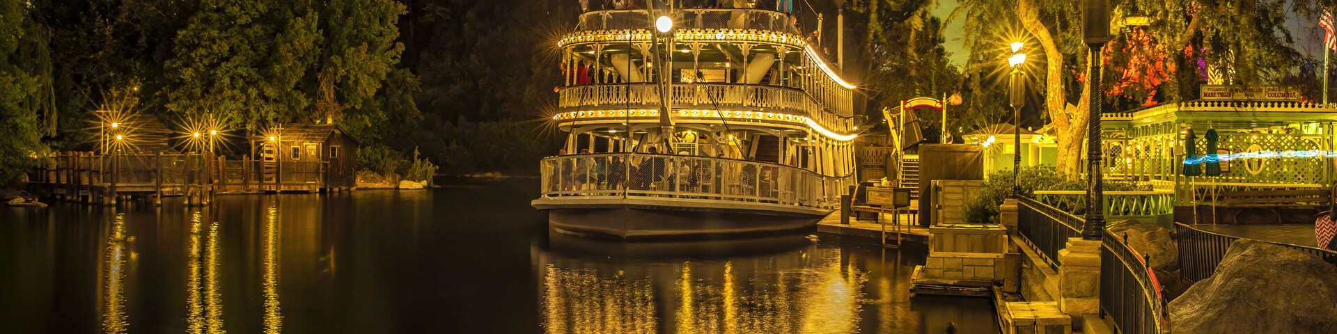 Anaheim, California, USA - July 27, 2023: Night view of a luxury steamboat with light moored on the river at the marina of Disneyland