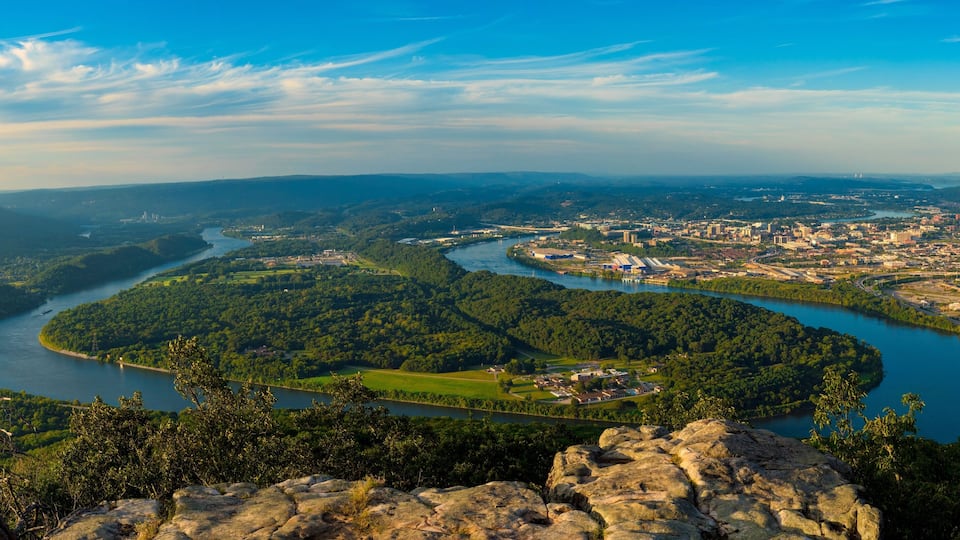 A river winding through a city surrounded by green hills.
