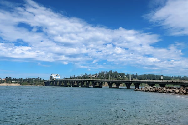 The Alsea Bay Bridge along coastal highway 101 connects Waldport and Bayshore on the Central Oregon Coast on a sunny spring day.