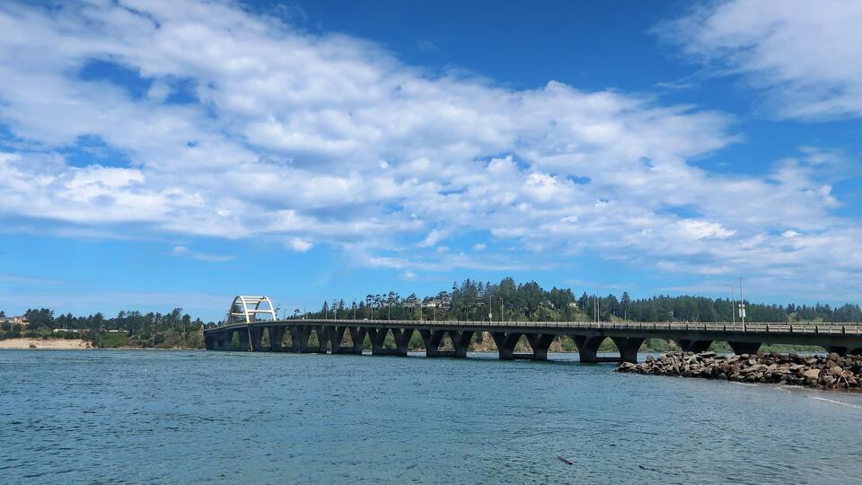 The Alsea Bay Bridge along coastal highway 101 connects Waldport and Bayshore on the Central Oregon Coast on a sunny spring day.