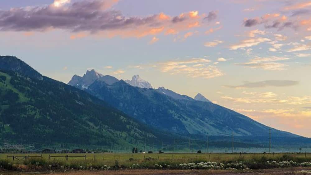 Just before dawn and the early sunlight is illuminating the skies and the Grand Tetons.
It was mid-July when this photo yet the mountains have snow on them still.