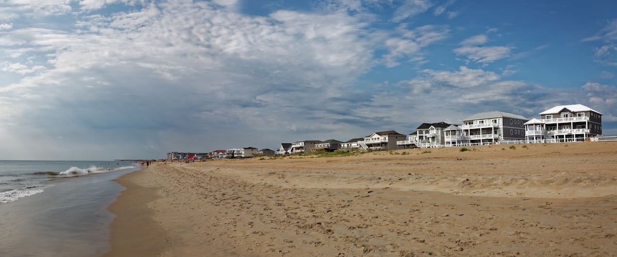 Outer Banks, North Carolina beach panorama. Sky, ocean, beach, and vacation rentals. Horizontal.