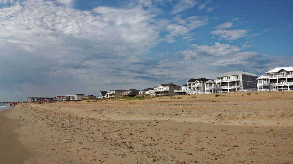 Outer Banks, North Carolina beach panorama. Sky, ocean, beach, and vacation rentals. Horizontal.