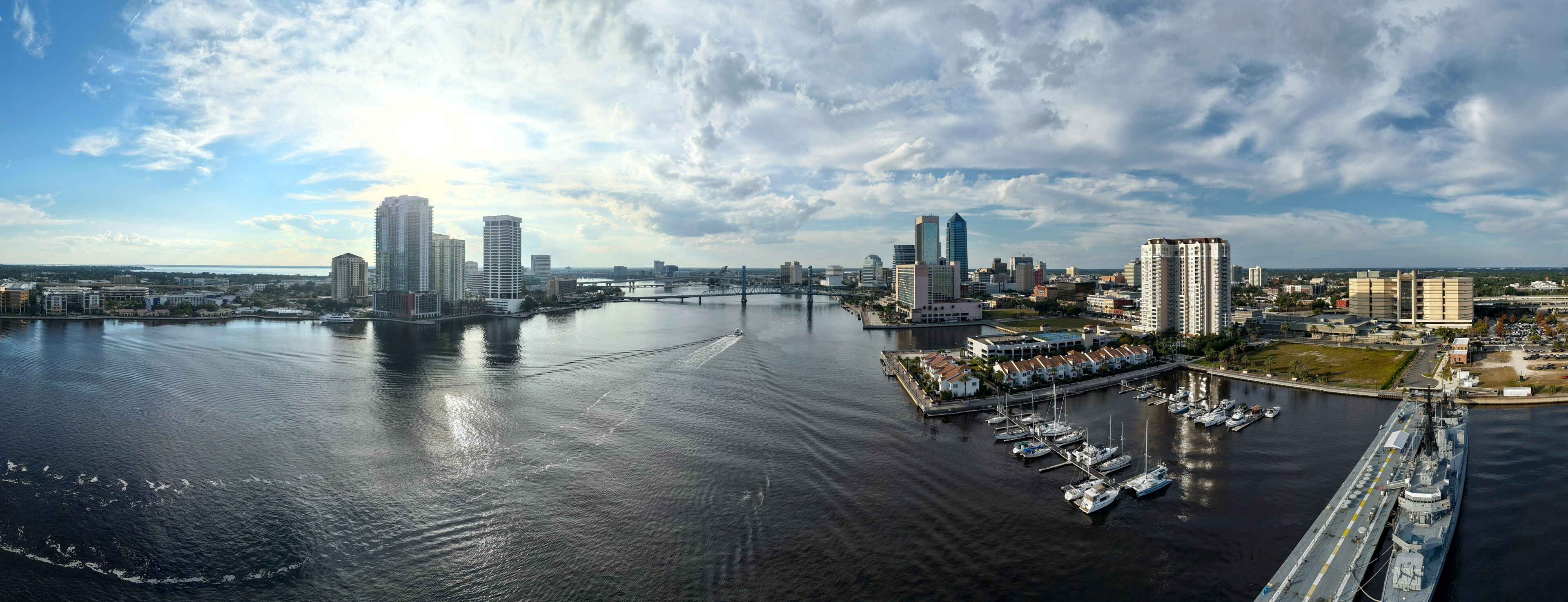 Aerial view of the St. Johns River reflecting the sunlight, cutting through the modern skyline and marina, Jacksonville, Florida, United States.