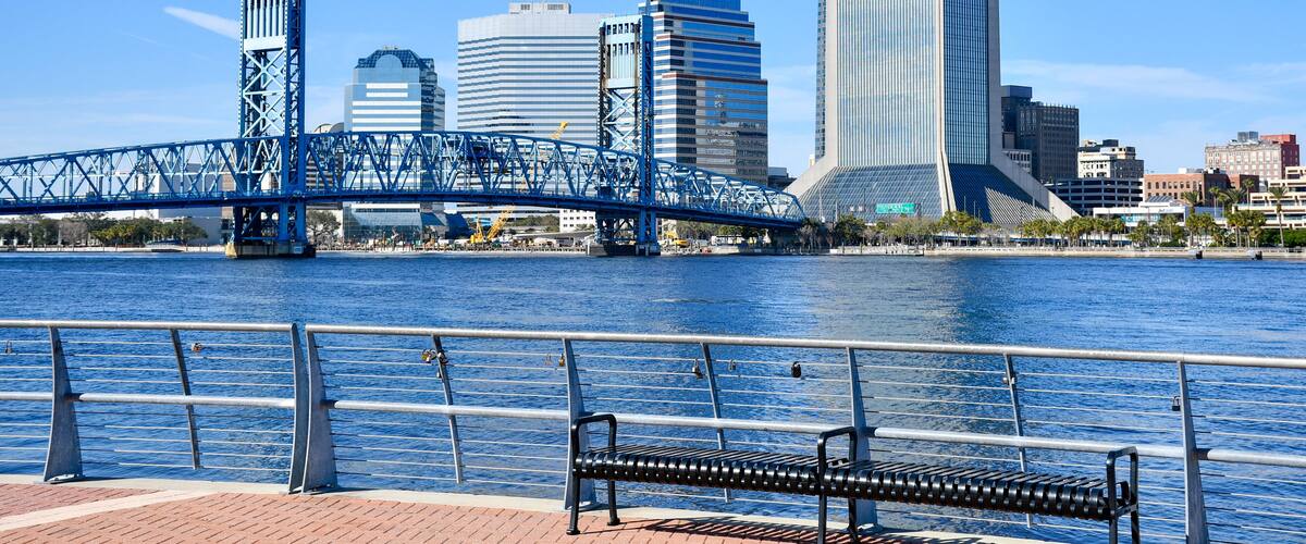Un río con un puente y un horizonte urbano al fondo.