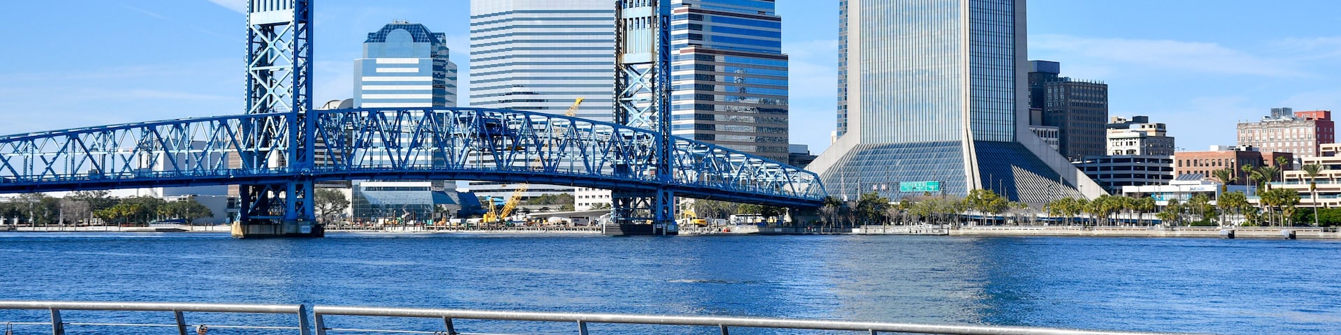 Ein Fluss mit einer Brücke und einer Stadtkulisse im Hintergrund.