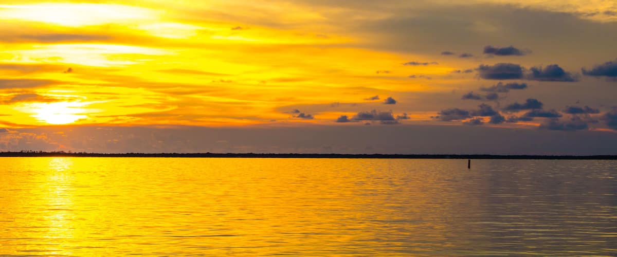 Dusk sunset above Gulf of Mexico ocean in Hudson Florida with orange sky