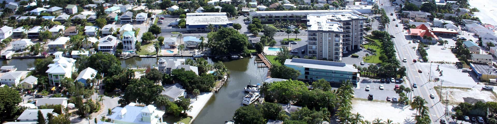 A coastal cityscape with a marina, dense housing, and a beach.