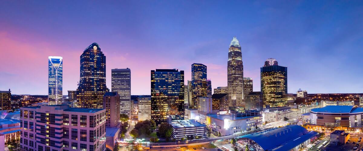 A city skyline with illuminated skyscrapers and a prominent dome-shaped building.