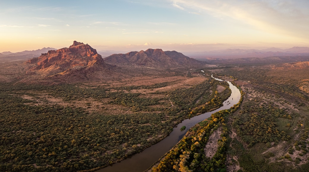 Un río serpentea por un paisaje montañoso con vegetación densa y un pico rocoso destacado.