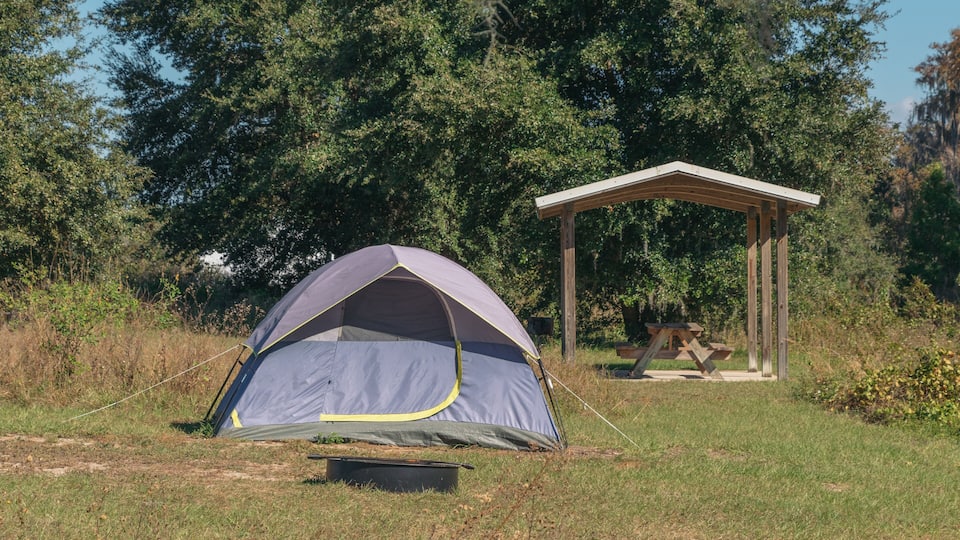 A camping area with a tent and a wooden pavilion.