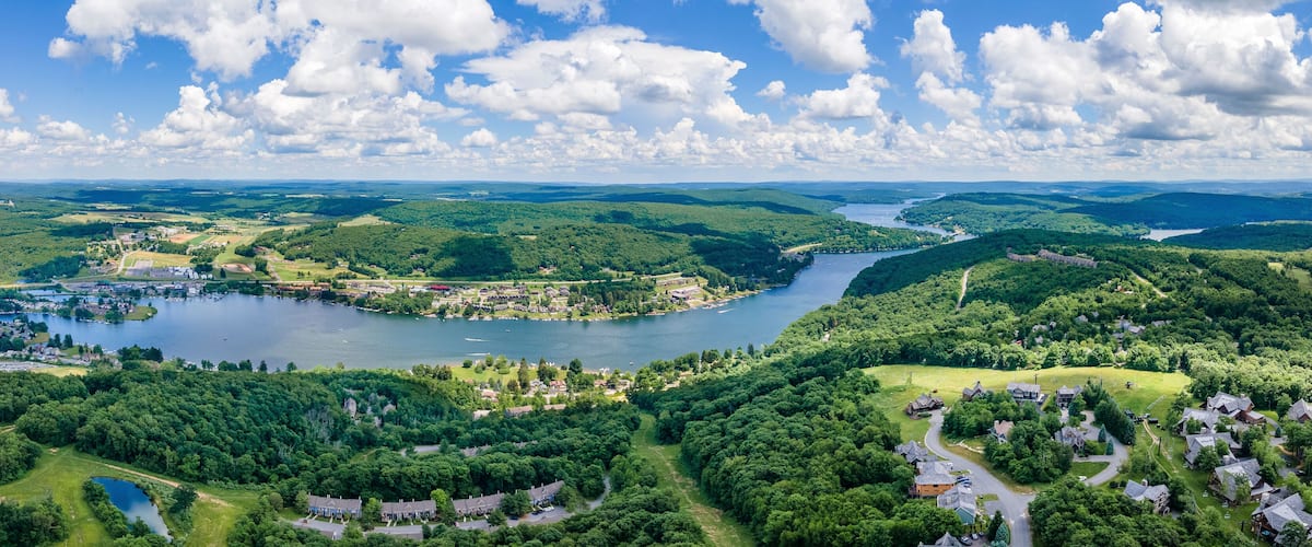 A river winding through a densely forested area with a small town and a lake.