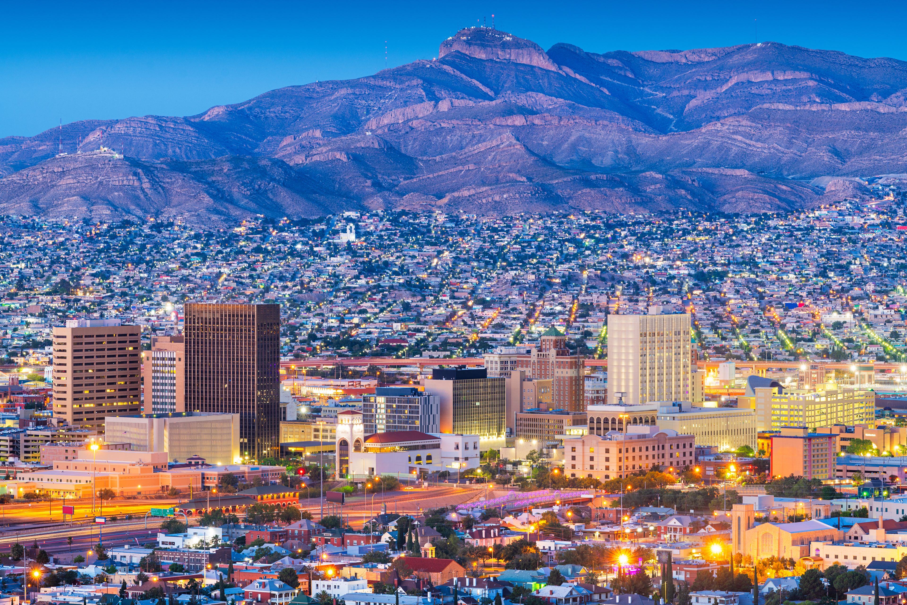 A cityscape with a mountain range in the background.