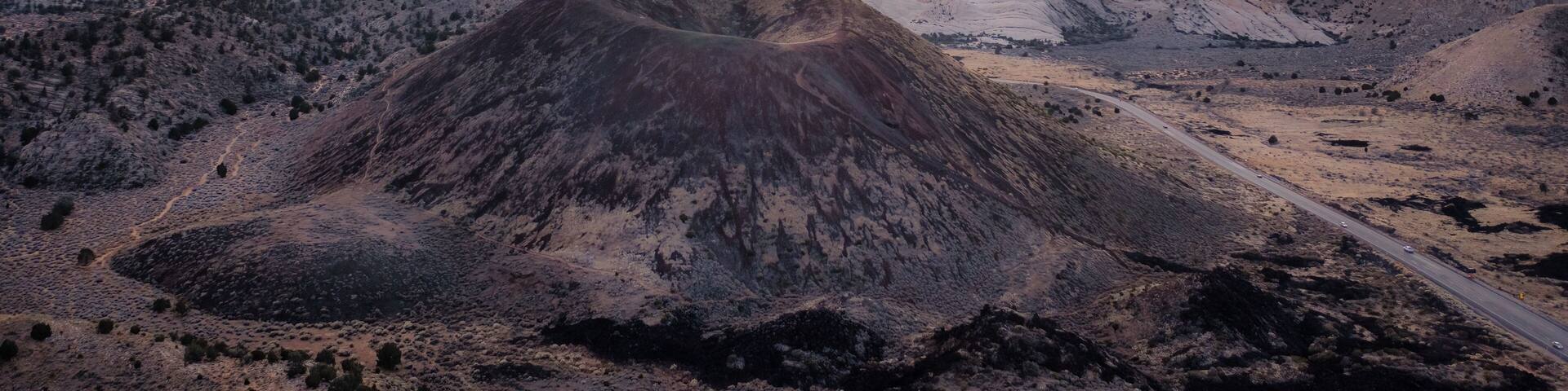 A mountainous landscape with a winding road and a clear sky.