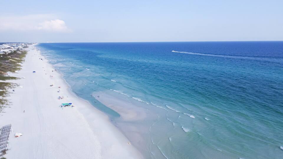 Miles of untouched beaches brilliantly white sand, crystal clear turquoise water with gorgeous shade of blue along upscale residential waterfront neighborhood in Santa Rosa, Florida, USA