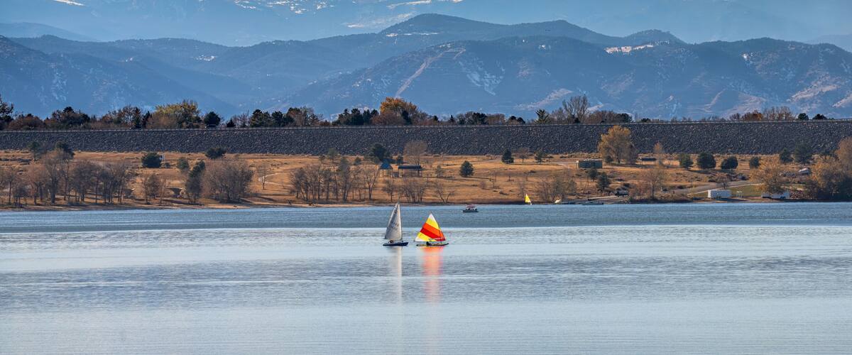 A peaceful Autumn day at Cherry Creek State Park in Colorado, with Sailboats on the lake and the Mountains visible in the background.