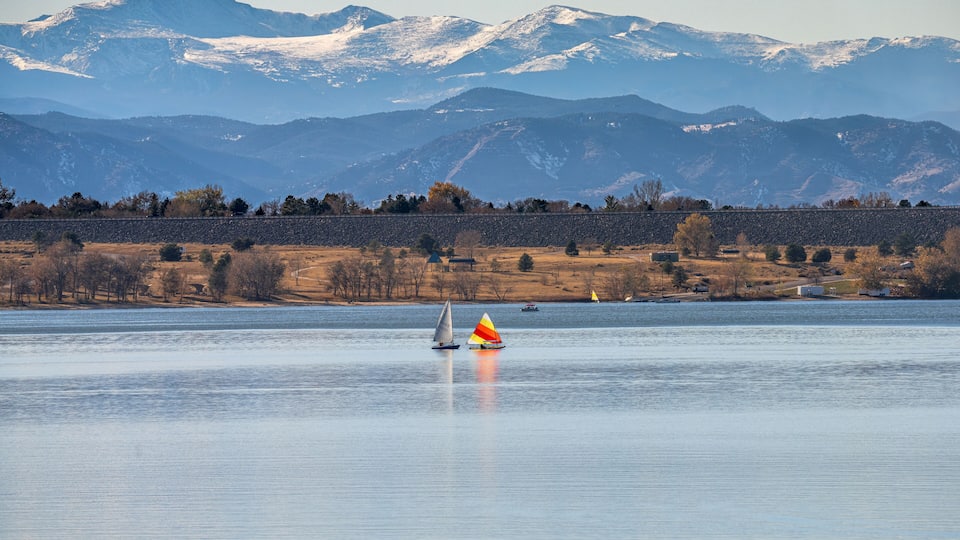 A peaceful Autumn day at Cherry Creek State Park in Colorado, with Sailboats on the lake and the Mountains visible in the background.