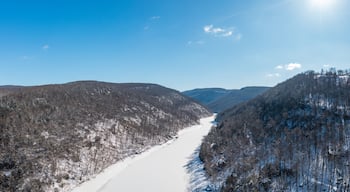 Aerial drone view of the snow-covered and frozen Cheat River flowing through the mountains towards the lake near Morgantown in West Virginia