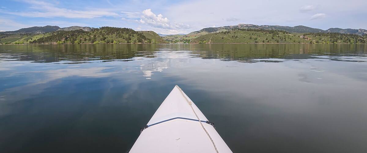 spring kayaking or canoeing on Horsetooth Reservoir at foothills of Rocky Mountains near Fort Collins, Colorado - POV paddler perspective