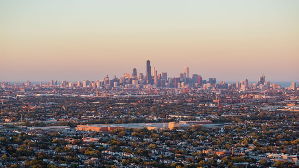 A city skyline with numerous high-rise buildings and a dense residential area in the foreground.
