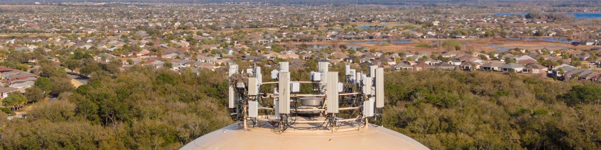 A large spherical structure with 'The Villages' written on it, surrounded by greenery and a residential area in the background.