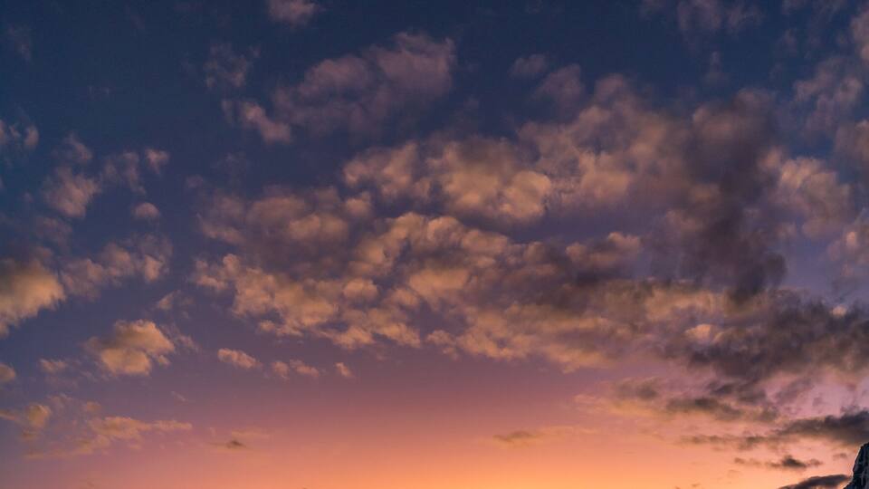 amazing sunset panorama over snowy mountain range with big glaciers with red, orange, violet and moonlight colors