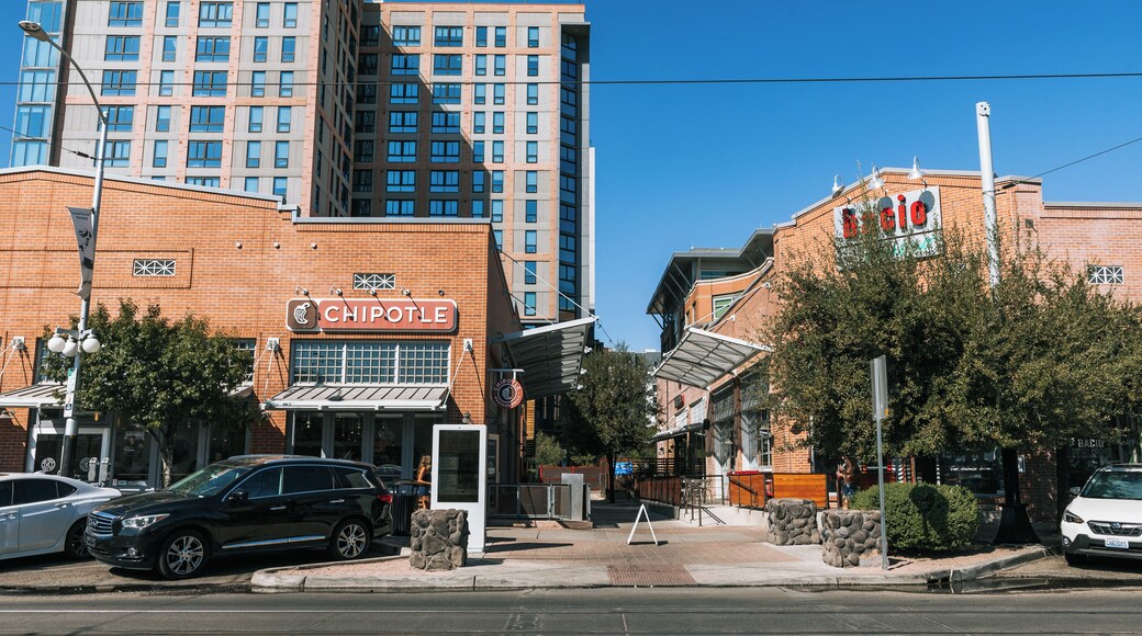 Un restaurante Chipotle, un coche blanco y un edificio con un letrero rojo.