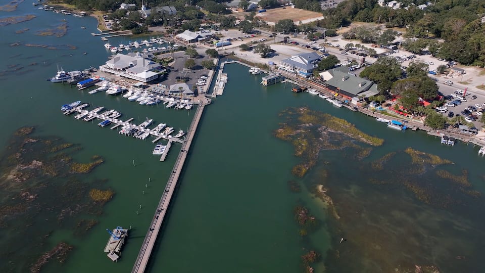 Murrells Inlet, SC marina and Inlet Marsh boardwalk extending over salt water tidal marsh also location is known as seafood restaurant capital of South Carolina