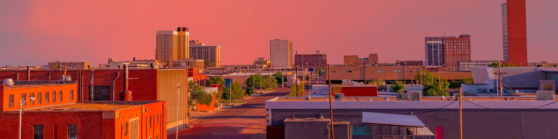 A brilliant sunset colors downtown Lubbock, Texas, including the streets and buildings.