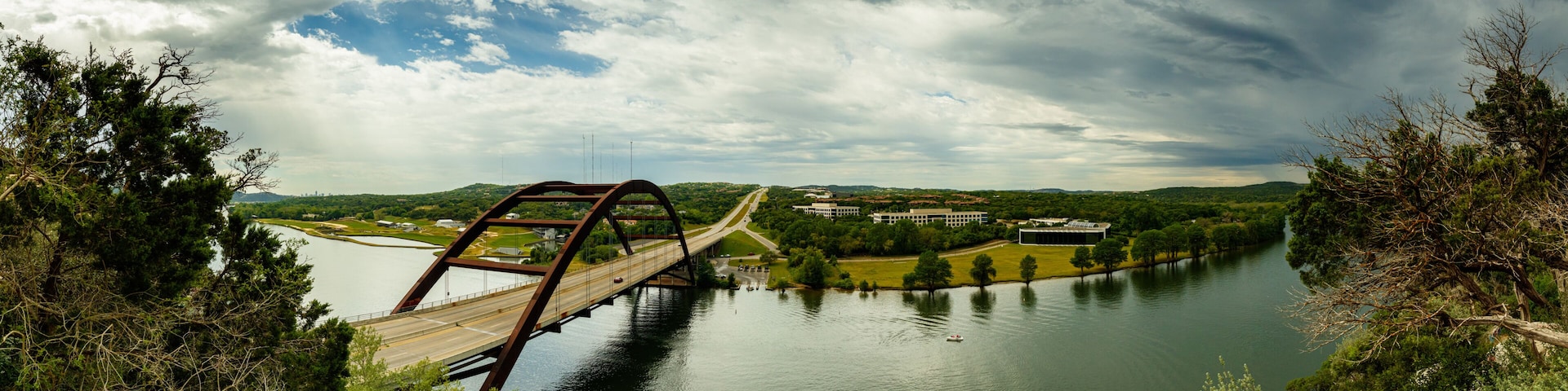 Un puente sobre un río con un paisaje urbano al fondo.