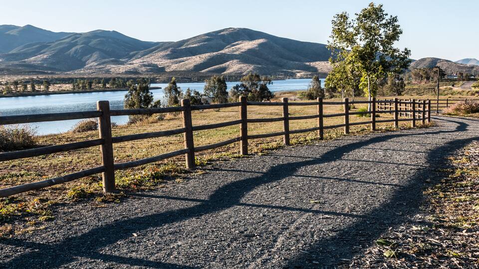 Pathway, trees, lake and mountains at Mountain Hawk Park in Chula Vista, California.