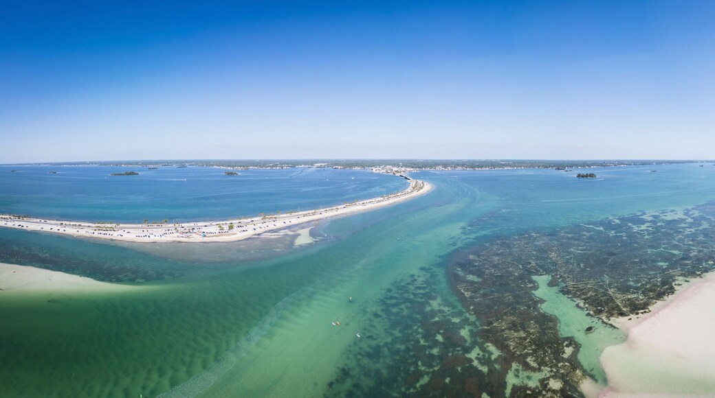 Aerial view of colorful boats navigating through Hurricane Pass and coral reef with sandy sandbanks, Dunedin, Florida, United States.
