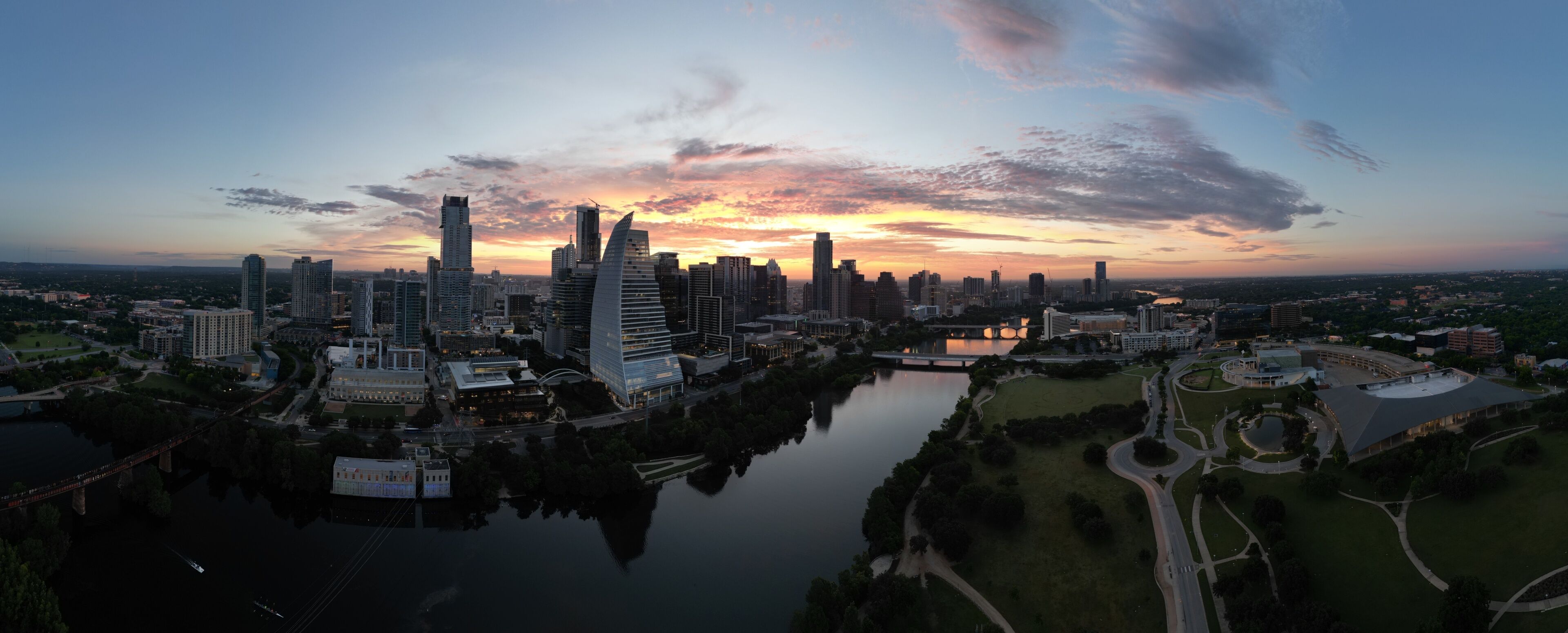 Downtown Austin Texas during early morning sunrise with orange red clouds in the horizon. 