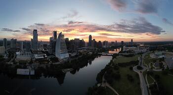 Downtown Austin Texas during early morning sunrise with orange red clouds in the horizon.