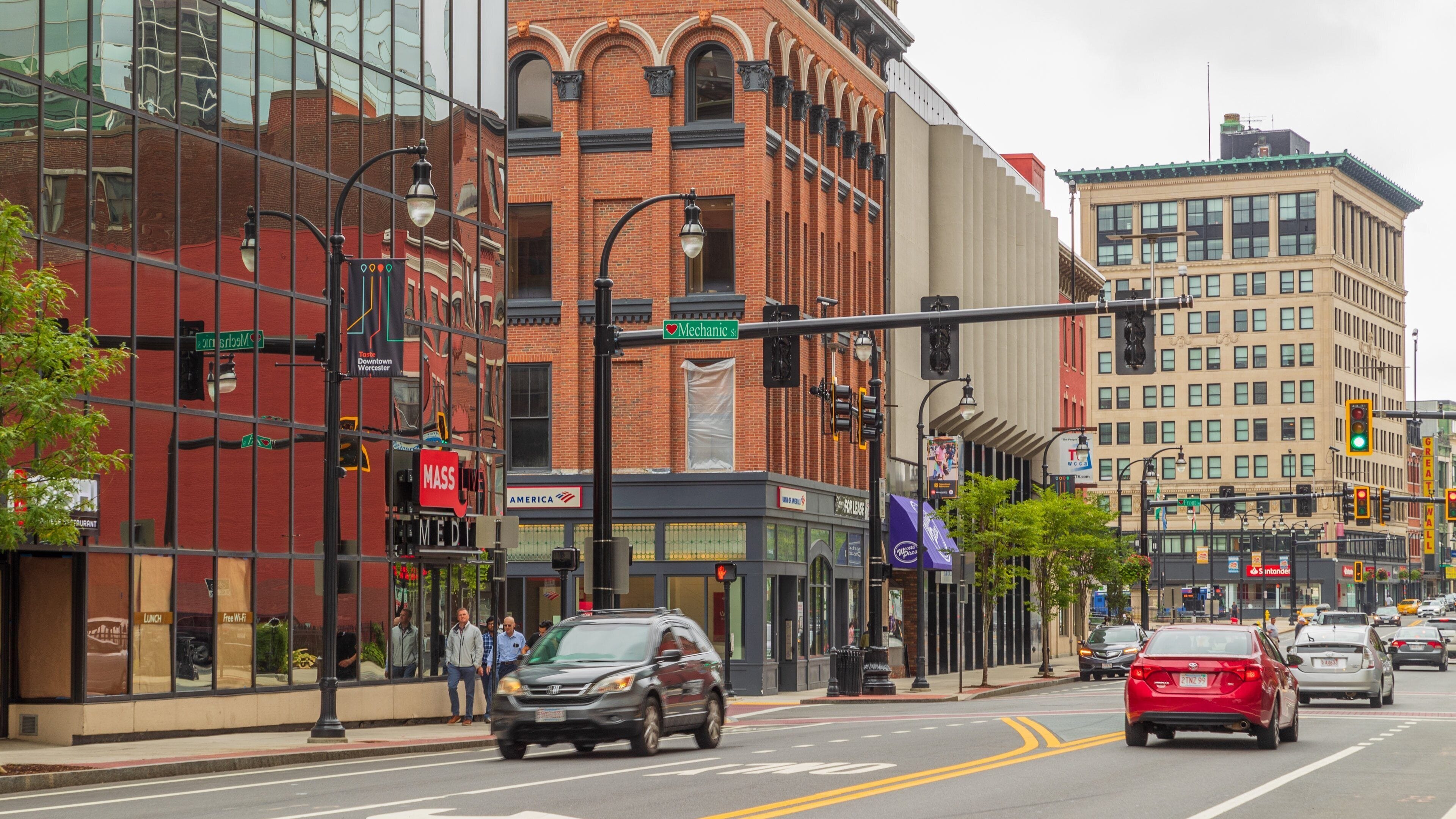 A busy urban street with historic buildings, a traffic light, and cars.