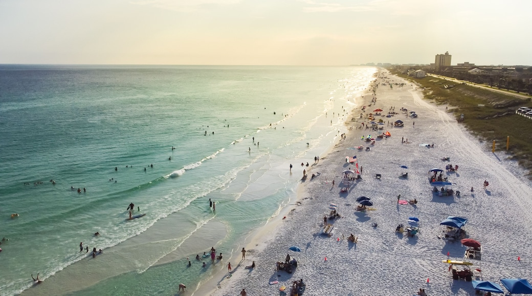 West of Miramar Beach in South Walton, Destin Florida with miles of sugar-white sandy beaches, turquoise water, gorgeous shade blue waves and crowed people relaxing, swimming, laid-back