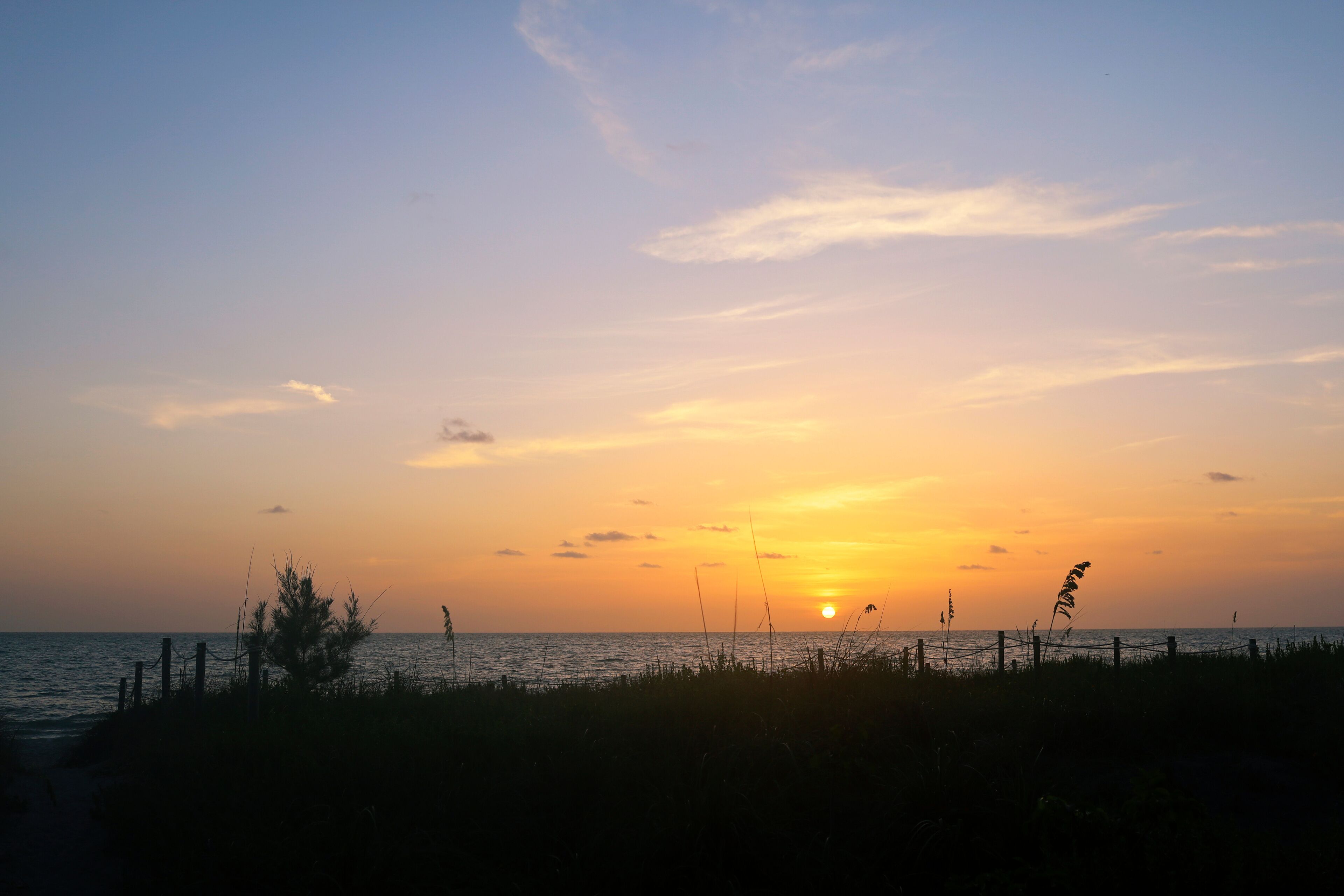 Sunset in Captiva Sanibel Island, Florida. Gulf of Mexico at dusk. Sun sets over beach on Captiva Island over calm waters. Illuminated dreamy summer sunset.