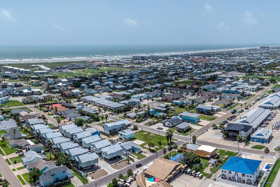 A coastal town with residential areas, a highway, and a beach.