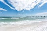 Fort Walton Beach, USA Okaloosa Island fishing pier in Florida in Panhandle, Gulf of Mexico during sunny day, wave crashing on shore, white sand