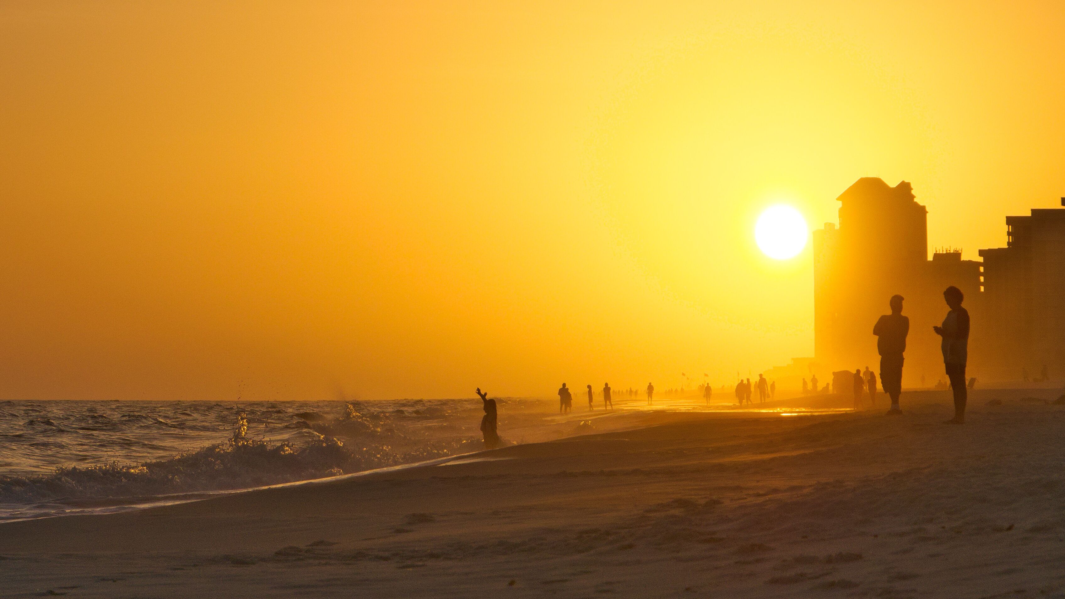 Sunset on Orange Beach Alabama with people in hazy fog