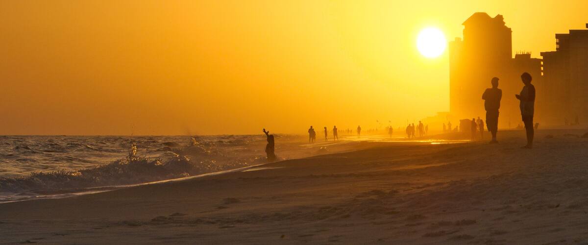 Sunset on Orange Beach Alabama with people in hazy fog